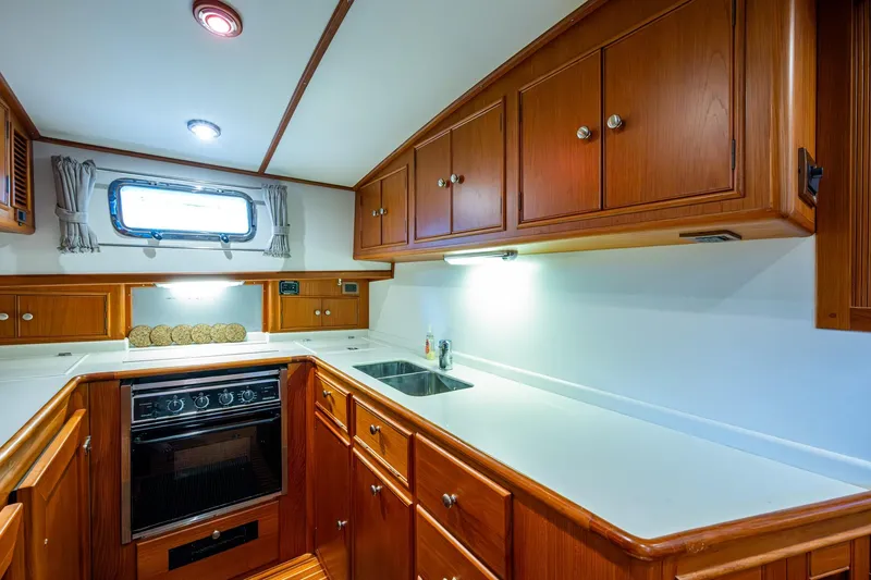 Bright Star Yacht Photos Pics Luxurious 2003 Grand Banks 49 Eastbay HX yacht kitchen with wood cabinetry and modern appliances.