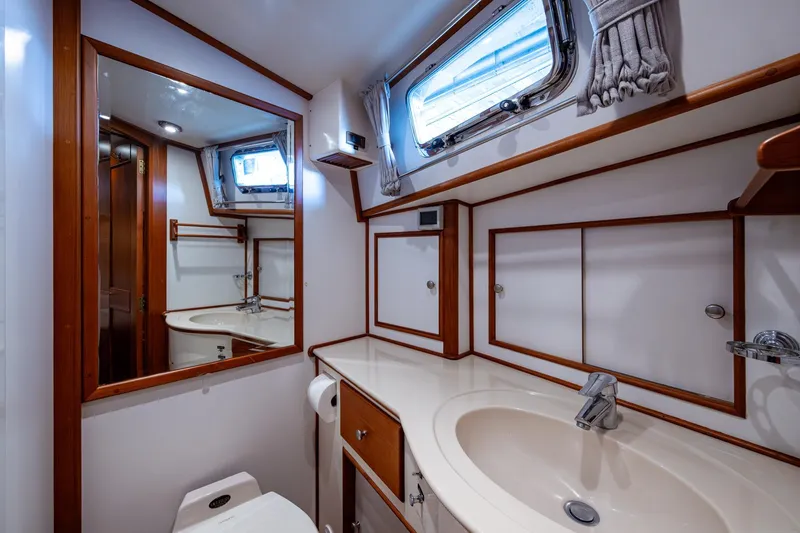 Bright Star Yacht Photos Pics Luxurious bathroom in 2003 Grand Banks 49 Eastbay HX yacht, featuring wood accents and modern fixtures.