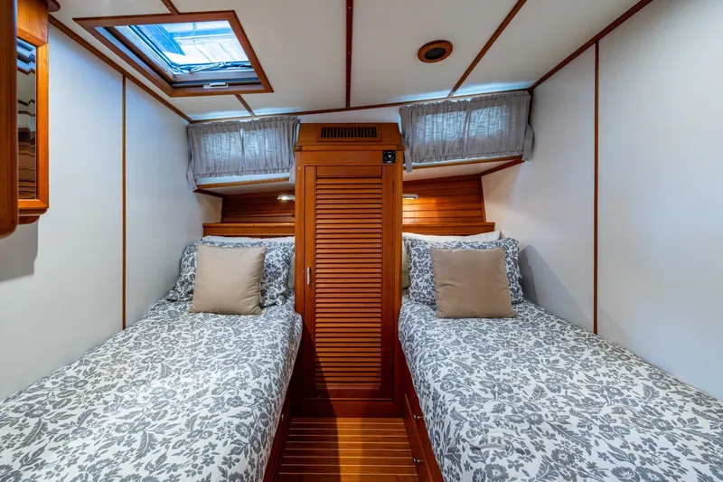Bright Star Yacht Photos Pics Cabin interior of 2003 Grand Banks 49 Eastbay HX with twin beds and wooden accents.