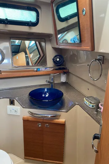 Sal-taire Yacht Photos Pics 2016 Ranger Tugs R-29S bathroom with blue vessel sink and wooden cabinetry.
