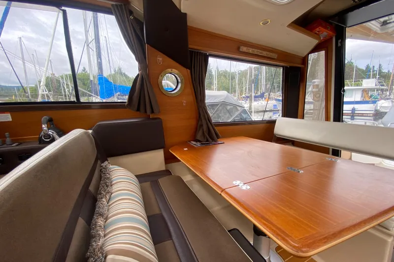 Sal-taire Yacht Photos Pics Interior of 2016 Ranger Tugs R-29S with wooden table and seating, marina view.