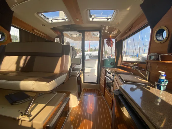 Sal-taire Yacht Photos Pics Interior of 2016 Ranger Tugs R-29S boat with seating, kitchen, and sunlight through windows.