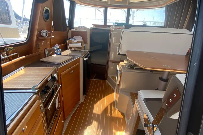 Sal-taire Yacht Photos Pics Interior of 2016 Ranger Tugs R-29S, featuring a compact kitchen and dining area.