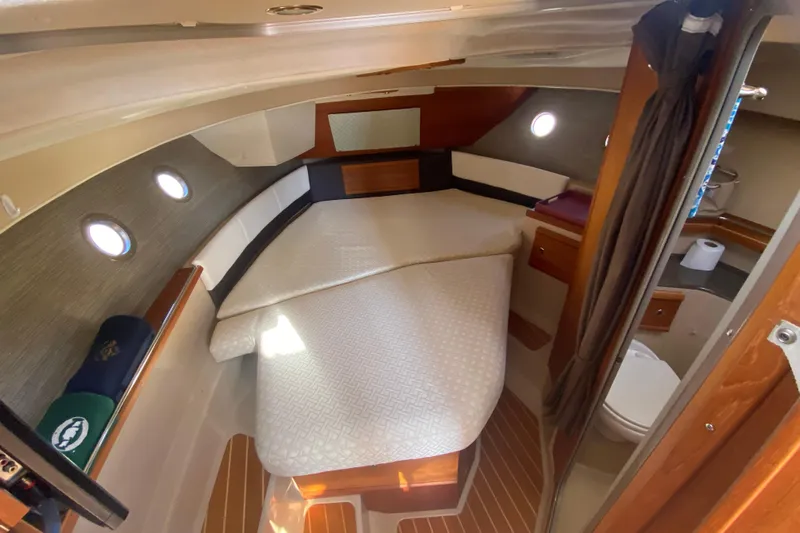Sal-taire Yacht Photos Pics 2016 Ranger Tugs R-29S cabin interior with bed, portholes, and wooden accents.