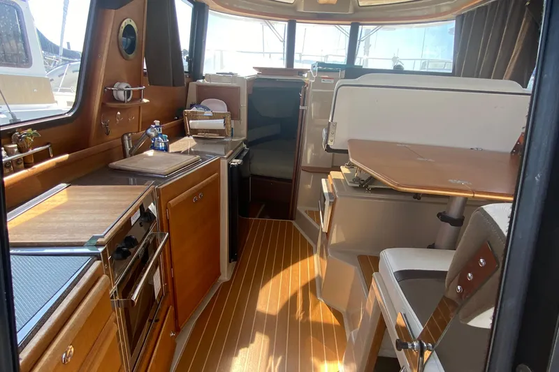 Sal-taire Yacht Photos Pics Interior of 2016 Ranger Tugs R-29S boat, featuring a compact kitchen and dining area.