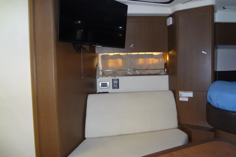 Rancho Del Lago Yacht Photos Pics 2017 Sea Ray Sundancer 350 interior with TV, beige seating, and wooden cabinetry.