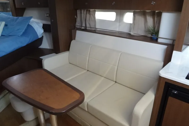 Rancho Del Lago Yacht Photos Pics Interior of 2017 Sea Ray Sundancer 350 with beige sofa and wooden table.