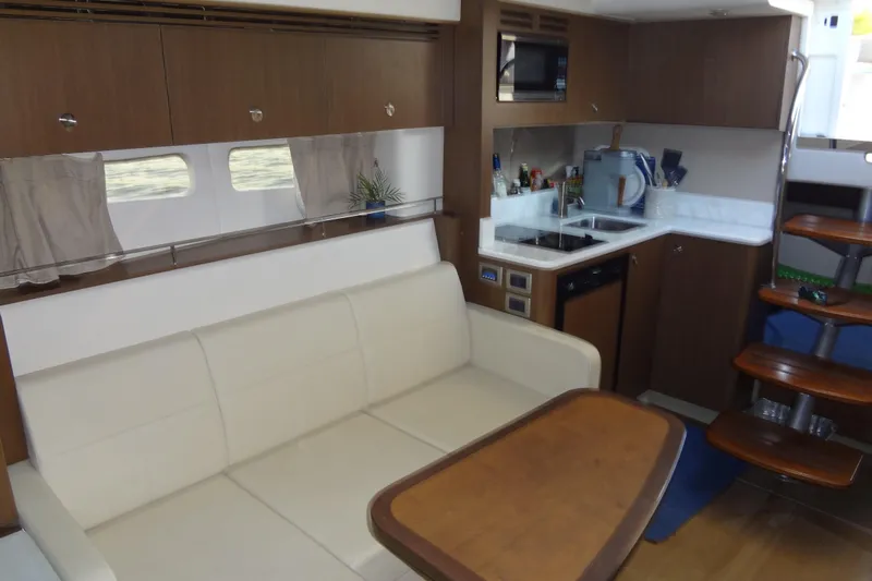 Rancho Del Lago Yacht Photos Pics 2017 Sea Ray Sundancer 350 interior with kitchen, sofa, and wooden stairs.