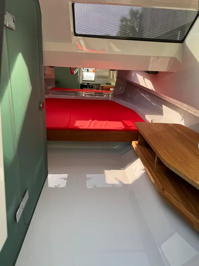  Yacht Photos Pics Interior of 2024 Goldfish 46 Open boat with red bedding and wooden furnishings.