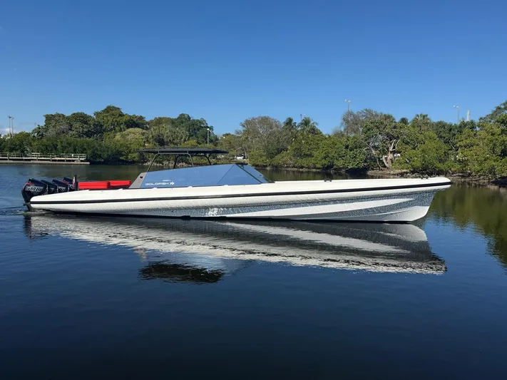  Yacht Photos Pics 2024 Goldfish 46 Open boat on calm water, surrounded by lush greenery.
