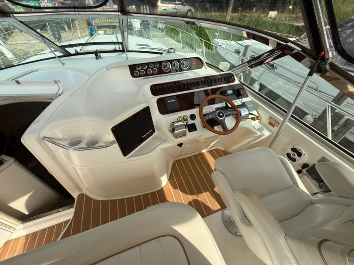 Seascape Yacht Photos Pics 1998 Sea Ray 400 Sundancer helm with wooden steering wheel and modern navigation equipment.