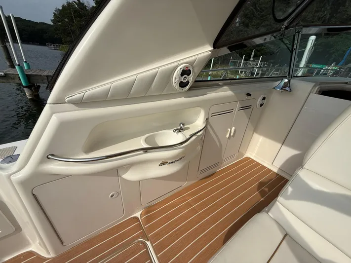 Seascape Yacht Photos Pics 1998 Sea Ray 400 Sundancer interior with sink and seating, docked by a lake.