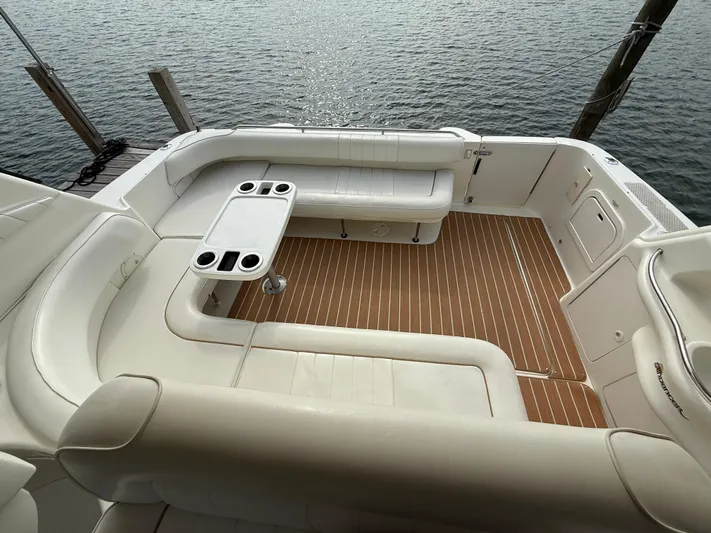 Seascape Yacht Photos Pics 1998 Sea Ray 400 Sundancer cockpit with white seating, table, and wood-style flooring by the water.