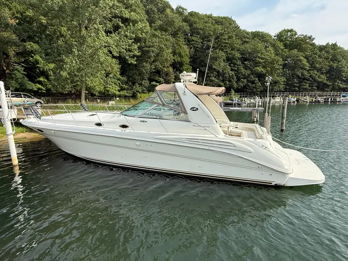 Seascape Yacht Photos Pics 1998 Sea Ray 400 Sundancer yacht docked by lush green trees.