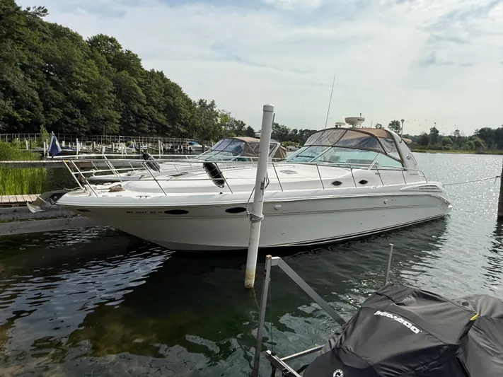 Seascape Yacht Photos Pics 1998 Sea Ray 400 Sundancer yacht docked on a serene lake with lush greenery.