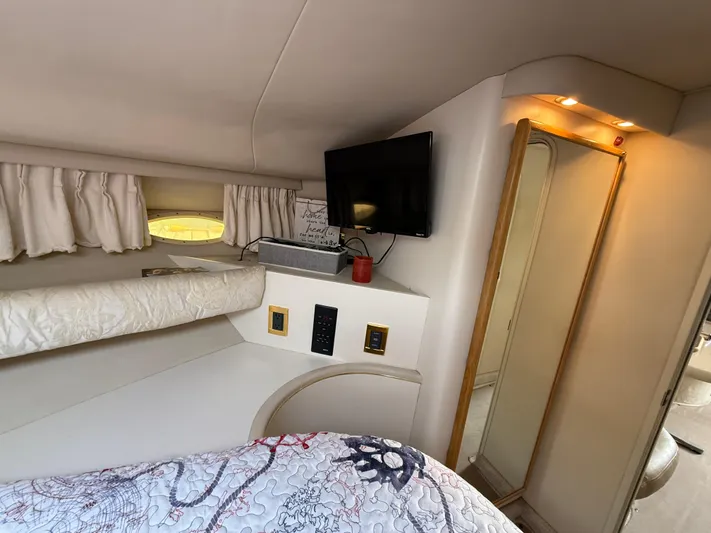 Seascape Yacht Photos Pics Interior cabin of 1998 Sea Ray 400 Sundancer with TV, mirror, and cozy bedding.