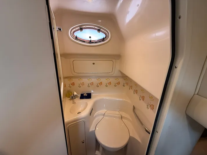 Seascape Yacht Photos Pics Bathroom interior of 1998 Sea Ray 400 Sundancer yacht with porthole and fish-themed decor.