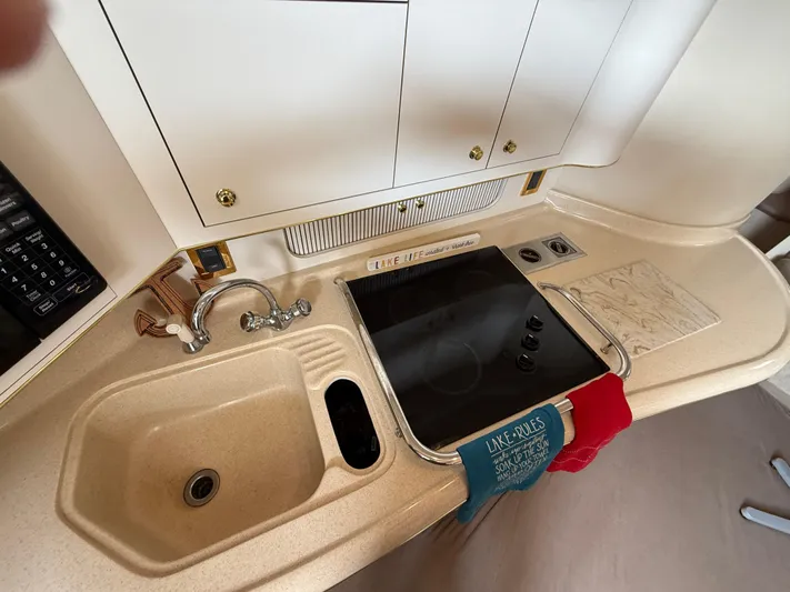 Seascape Yacht Photos Pics 1998 Sea Ray 400 Sundancer kitchen with sink, stove, and cabinets.