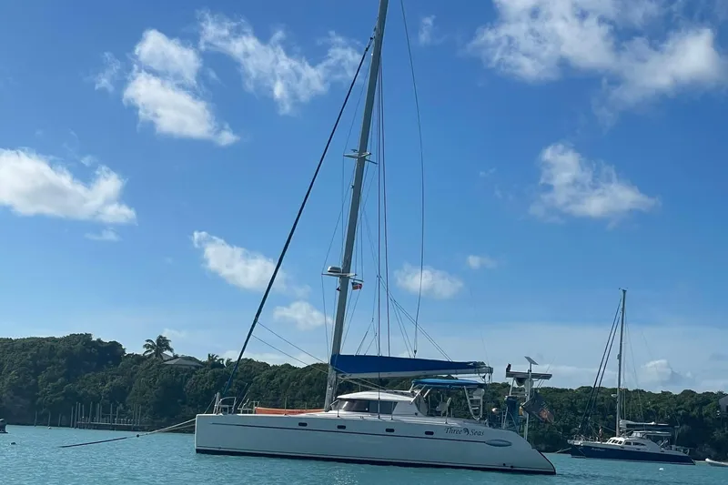 Three Seas Yacht Photos Pics 2002 Fountaine Pajot Belize 43 catamaran anchored in a scenic bay under a clear blue sky.