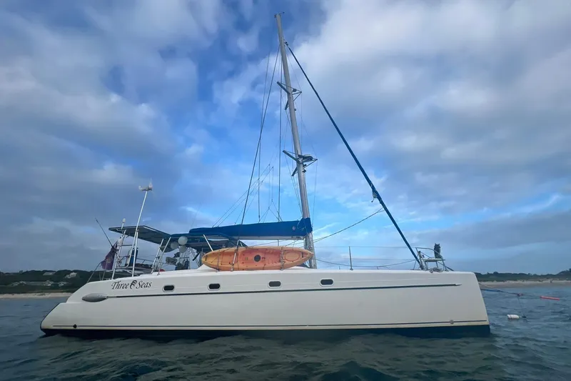 Three Seas Yacht Photos Pics 2002 Fountaine Pajot Belize 43 catamaran anchored under cloudy sky.