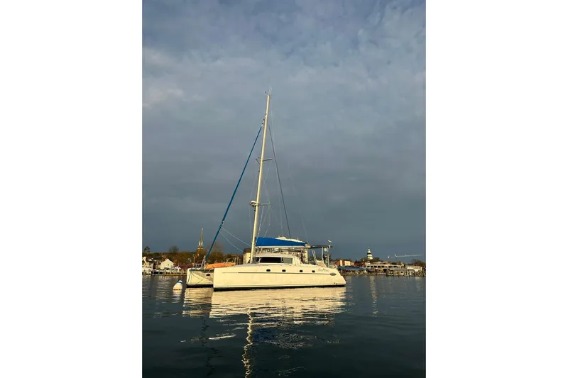Three Seas Yacht Photos Pics 2002 Fountaine Pajot Belize 43 catamaran anchored in calm waters at sunset.