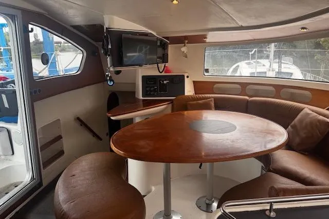Three Seas Yacht Photos Pics Interior of 2002 Fountaine Pajot Belize 43 catamaran with round table and seating area.