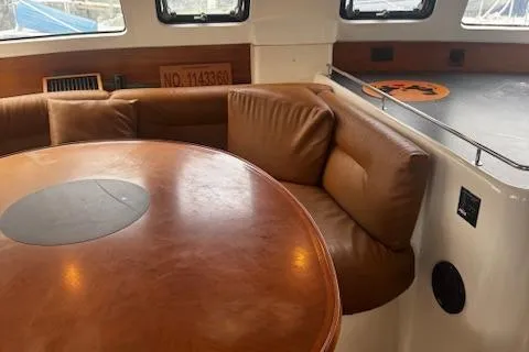 Three Seas Yacht Photos Pics Interior of 2002 Fountaine Pajot Belize 43 yacht with leather seating and round table.