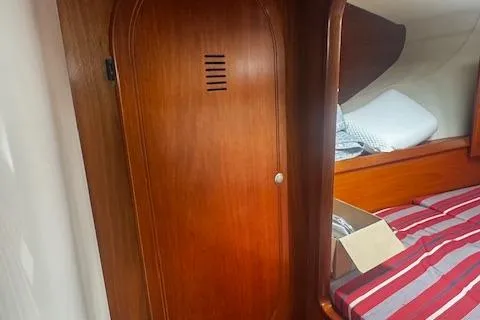 Three Seas Yacht Photos Pics Interior cabin of 2002 Fountaine Pajot Belize 43 with wooden door and striped bedding.
