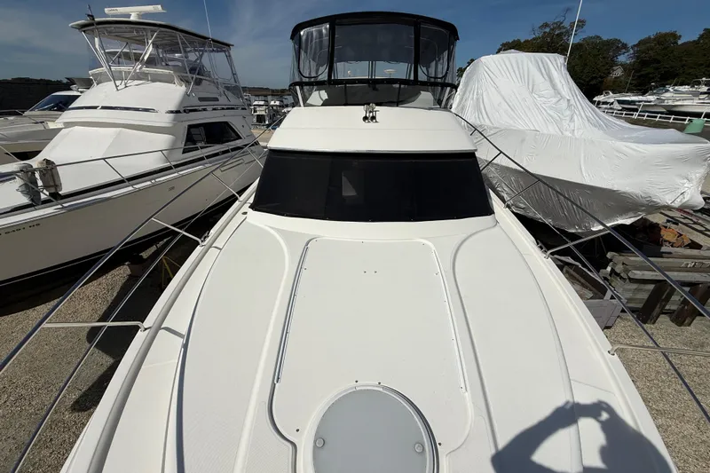  Yacht Photos Pics 2005 Silverton 38 Sport Bridge yacht docked, surrounded by other boats, under clear skies.