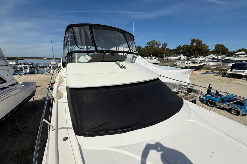  Yacht Photos Pics 2005 Silverton 38 Sport Bridge yacht docked at a marina under clear skies.