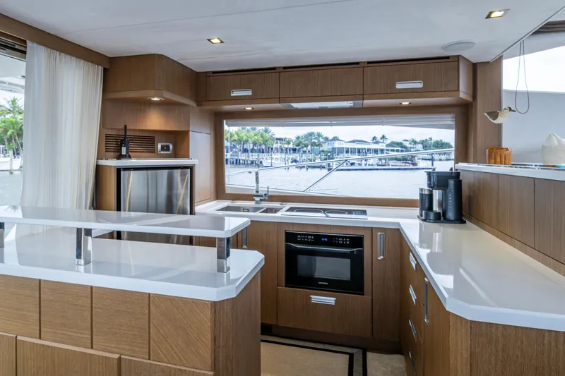 Sunshine Yacht Photos Pics Luxurious kitchen interior of 2020 Galeon 550 Fly yacht with modern appliances and waterfront view.