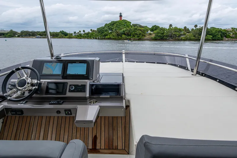 Sunshine Yacht Photos Pics 2020 Galeon 550 Fly yacht helm with dual screens, overlooking serene waters and lush greenery.
