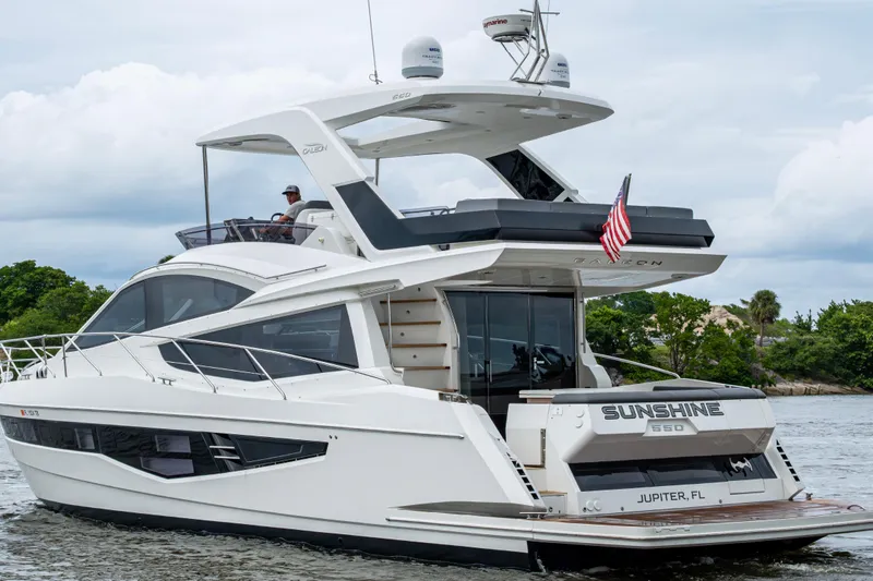 Sunshine Yacht Photos Pics 2020 Galeon 550 Fly yacht cruising on water, featuring sleek design and American flag.