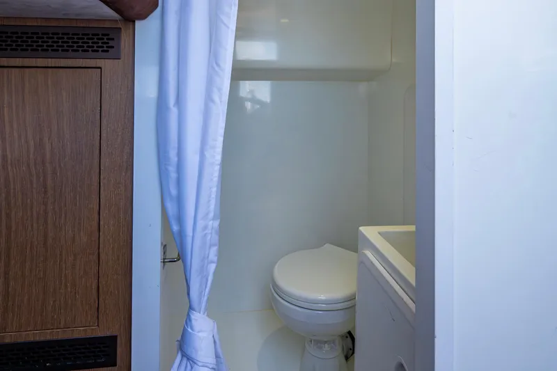 Sunshine Yacht Photos Pics Bathroom interior of 2020 Galeon 550 Fly yacht with white curtain and wooden cabinet.