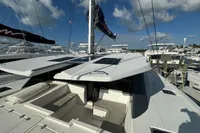 Leopard 50 catamaran deck with solar panels, docked at marina, under blue sky.