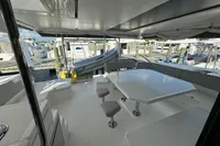 Spacious deck of 2020 Leopard 50 yacht with seating and table at marina.