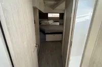 Narrow hallway in 2020 Leopard 50 yacht leading to cozy bedroom.