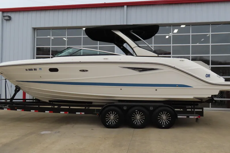  Yacht Photos Pics 2021 Sea Ray 310 SLX boat on trailer, parked outside a garage.