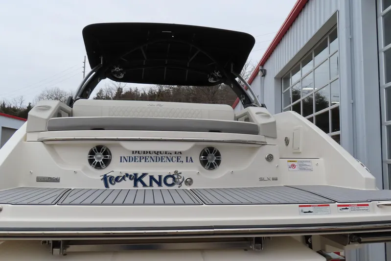  Yacht Photos Pics 2021 Sea Ray 310 SLX boat rear view with custom lettering, docked near a building.
