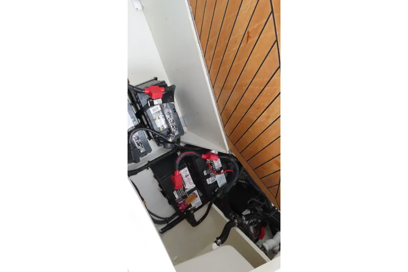  Yacht Photos Pics 2021 Sea Ray 310 SLX boat battery compartment with wiring and wooden paneling.
