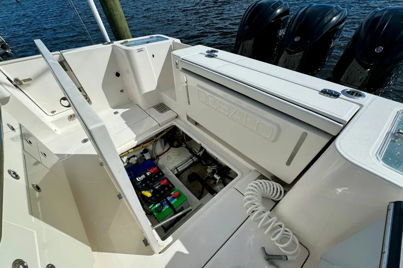 No Joke Yacht Photos Pics 2022 Robalo R360 Center Console boat with open storage compartment and visible engines.