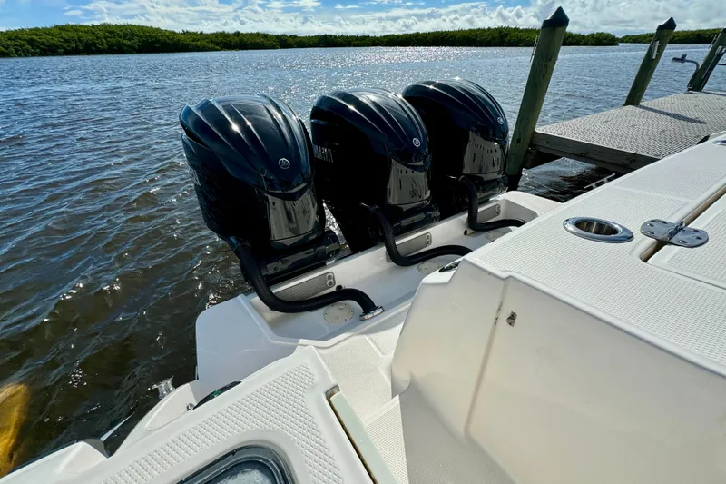 No Joke Yacht Photos Pics 2022 Robalo R360 Center Console with triple outboard engines docked by the water.