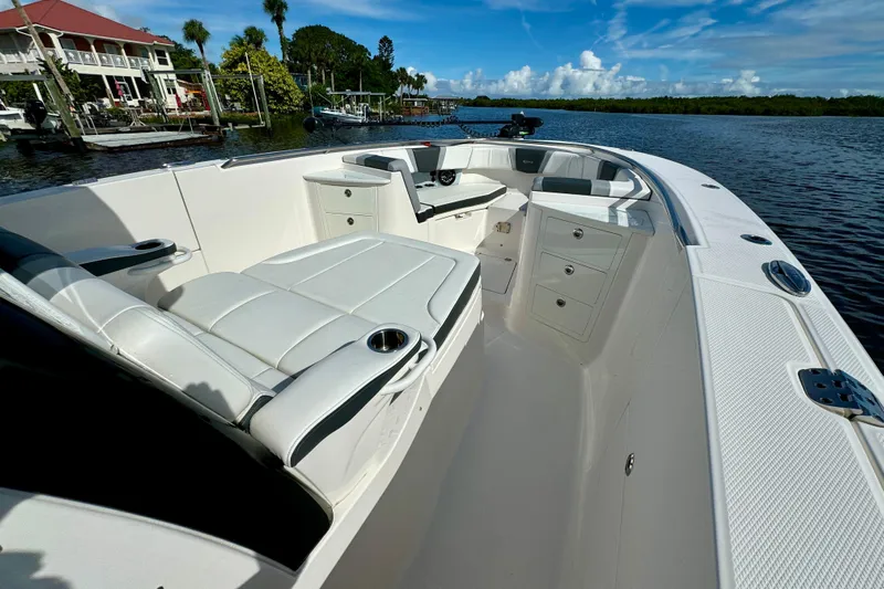 No Joke Yacht Photos Pics 2022 Robalo R360 Center Console boat interior with seating and storage, docked by waterfront homes.