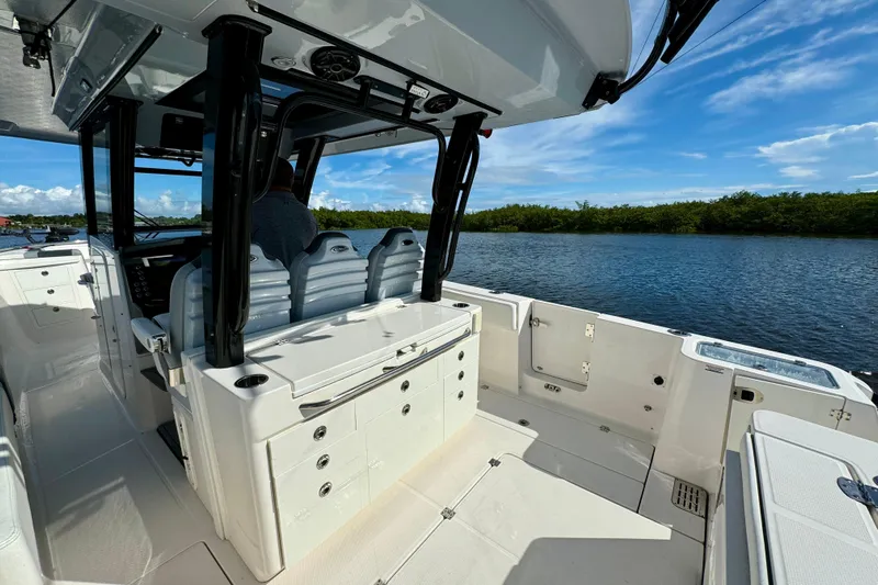 No Joke Yacht Photos Pics 2022 Robalo R360 Center Console boat interior with seating and storage, on a sunny day.