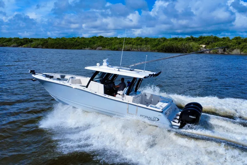 No Joke Yacht Photos Pics 2022 Robalo R360 Center Console boat cruising on open water, under a blue sky.