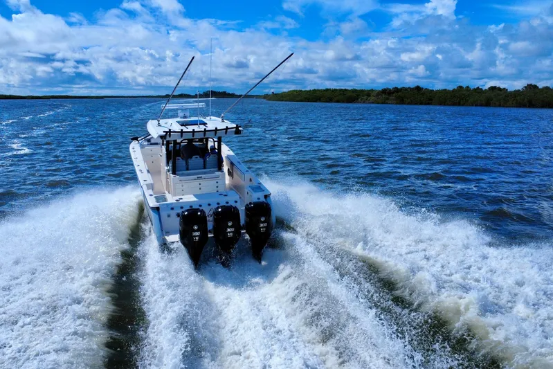 No Joke Yacht Photos Pics 2022 Robalo R360 Center Console boat cruising on open water, creating a wake.