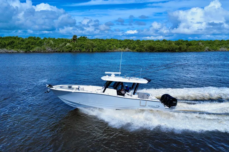 No Joke Yacht Photos Pics 2022 Robalo R360 Center Console boat cruising on a scenic waterway.