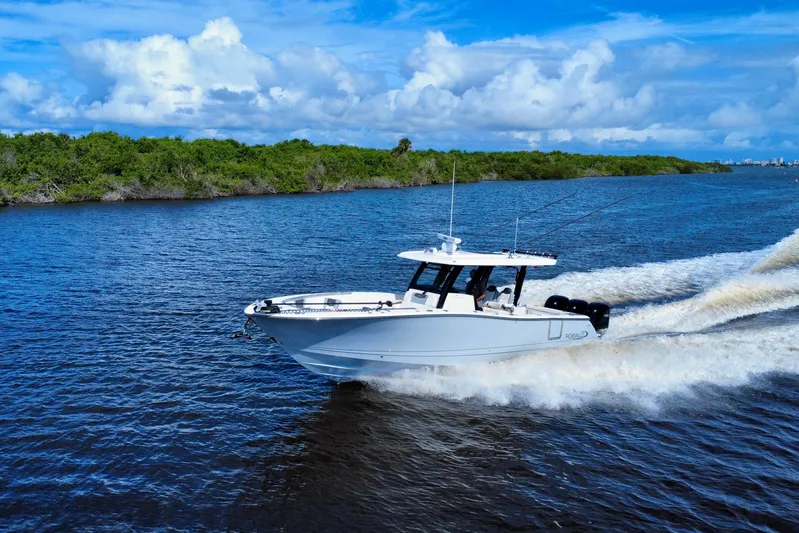 No Joke Yacht Photos Pics 2022 Robalo R360 Center Console boat cruising on a scenic waterway.