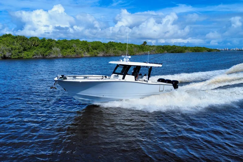 No Joke Yacht Photos Pics 2022 Robalo R360 Center Console boat cruising on a scenic waterway.