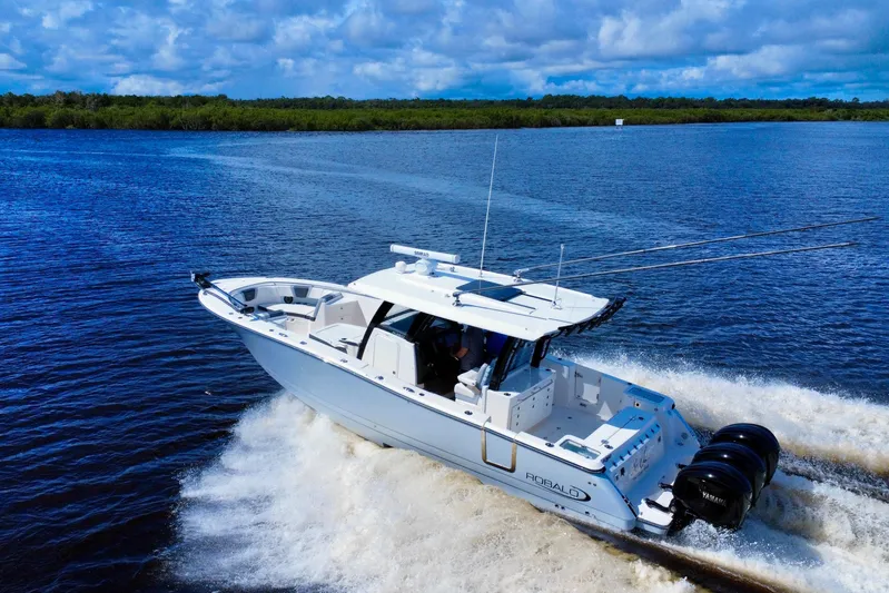 No Joke Yacht Photos Pics 2022 Robalo R360 Center Console boat cruising on a scenic waterway.